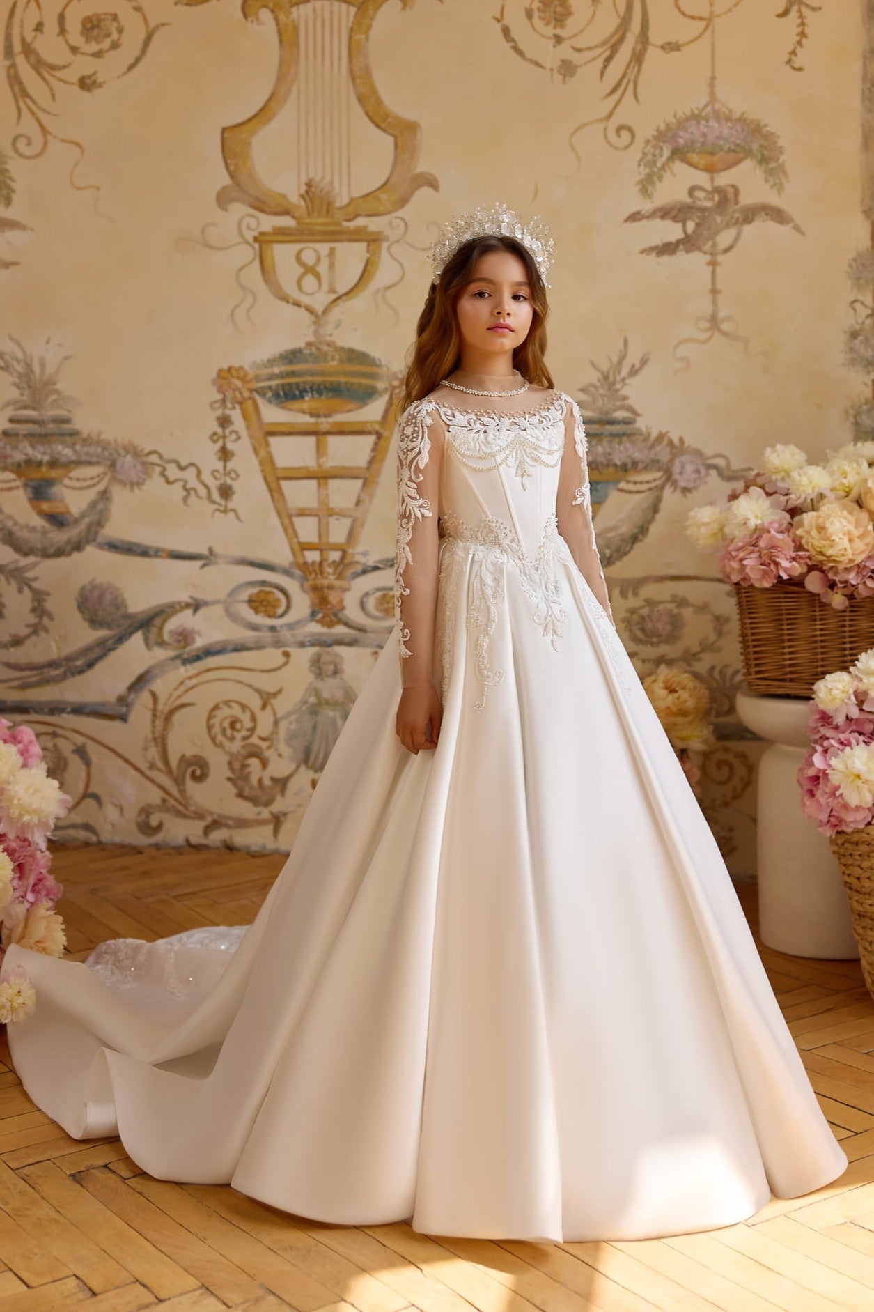 Full-length Communion dress with embroidered sleeves and dramatic train, styled with a floral tiara