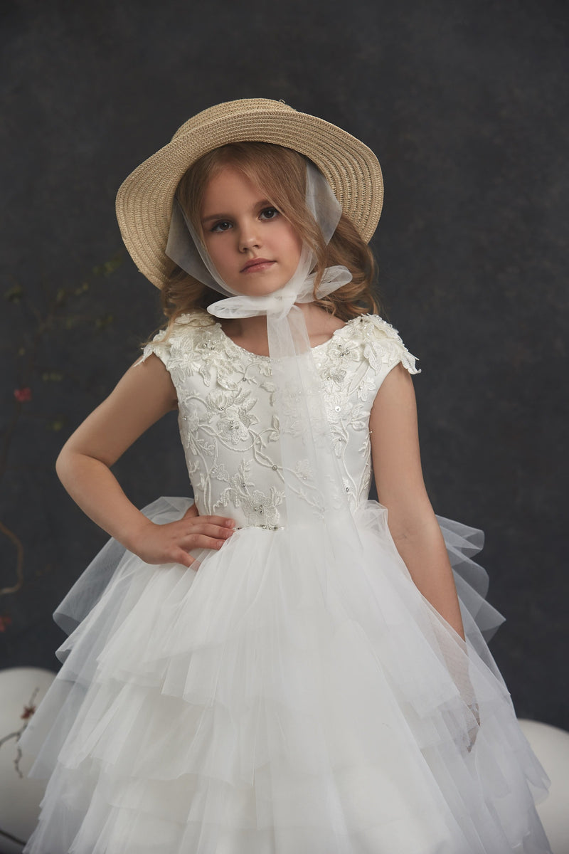 Young girl in Girls Open Back Tulle High-Low Dress with lace details and a straw hat against a dark background