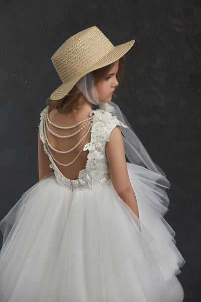 Young girl in Girls Open Back Tulle High-Low Dress and straw hat against a dark background
