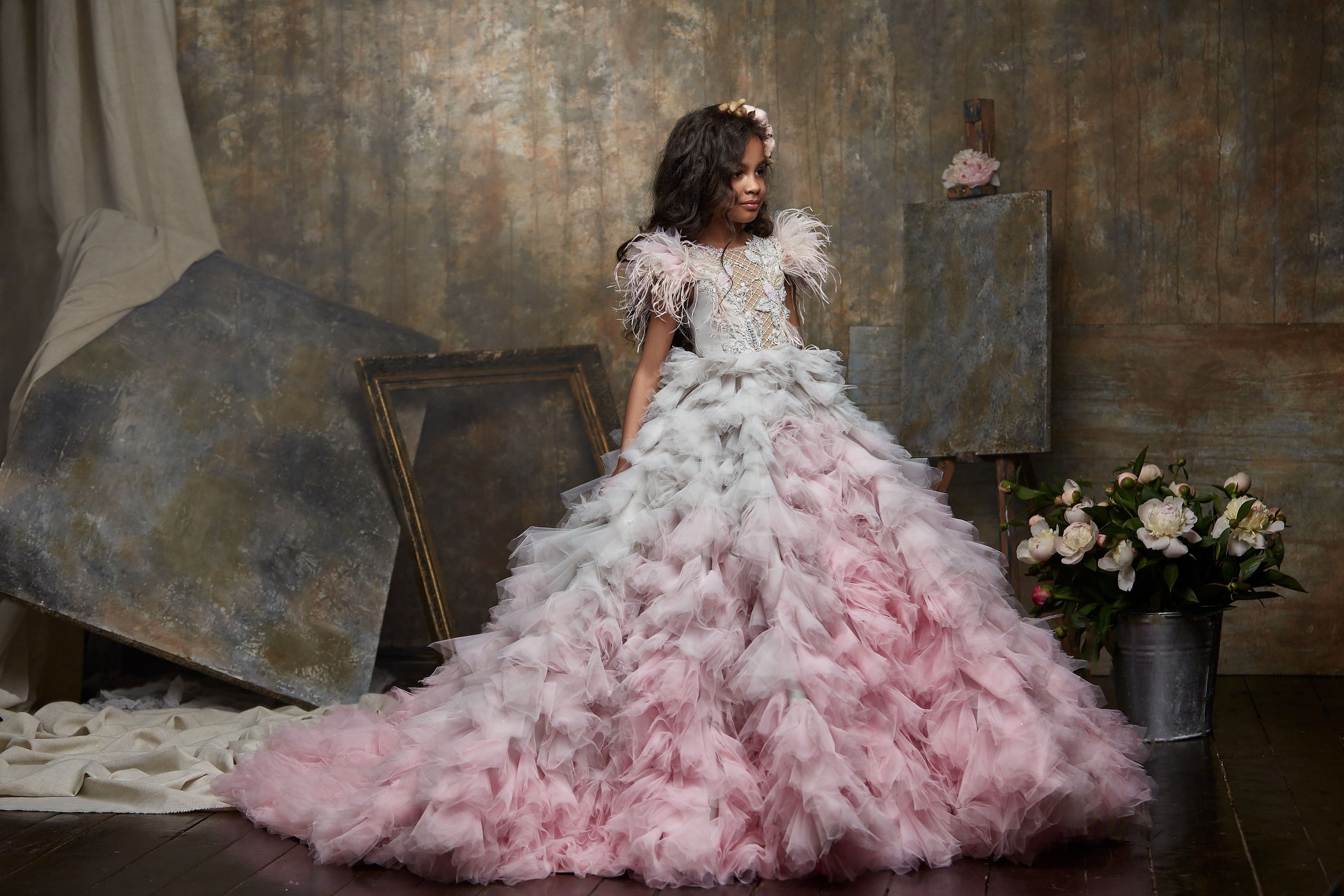 Woman in Girls Ruffle Ombre Maxi Dress with a Train standing in an artistic studio setting.