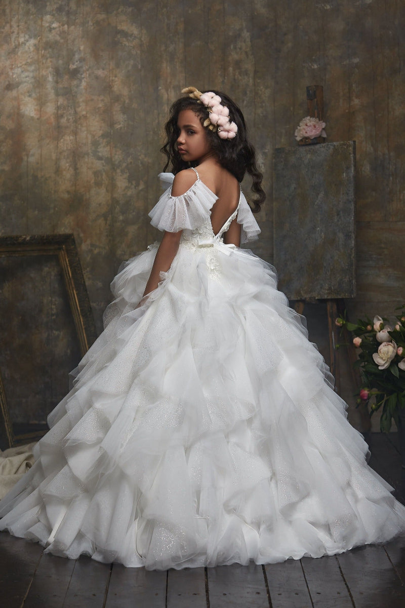 Young girl in Girl's Ruffled Sparkly Long Princess Dress with floral hairpiece in a rustic setting
