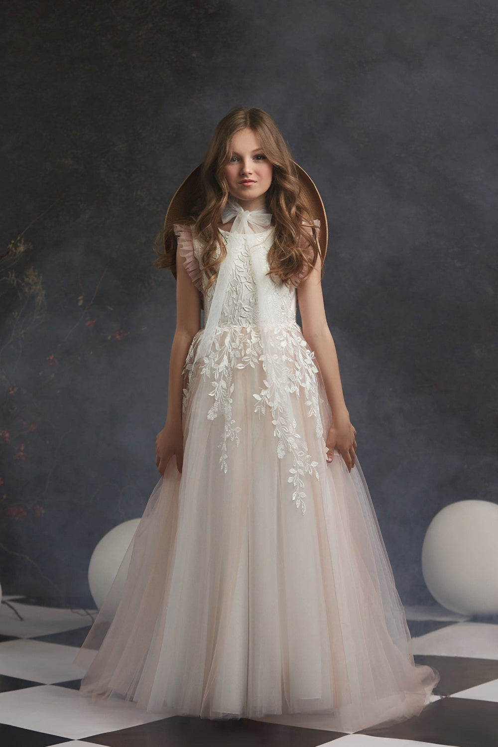 Girl wearing Leaf Pattern Blush Flower Girl Dress lace dress against a dark background