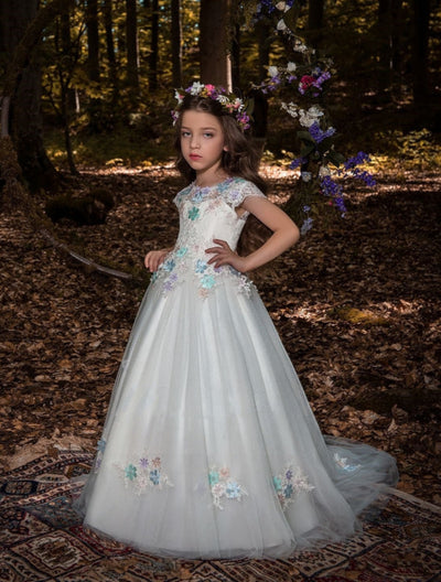Young girl in Los Angeles Flower Girl Dress with Pastel Flower Embroidery standing in a forest setting