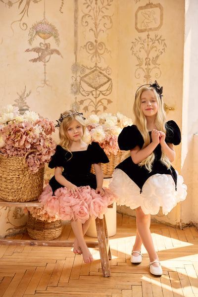 Two girls wearing couture black velvet flower girl dresses