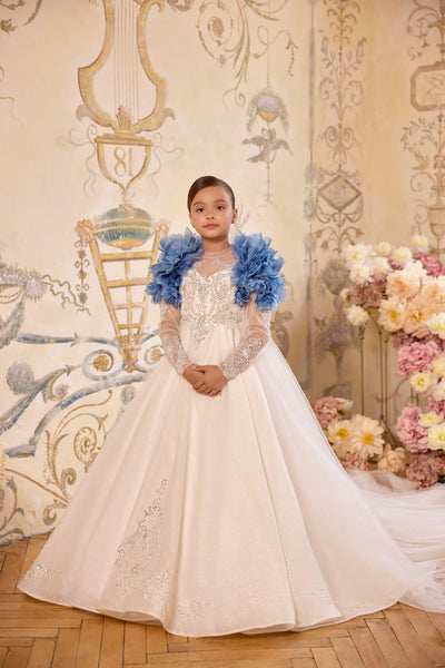 Girl wearing blue floral statement cape over communion gown