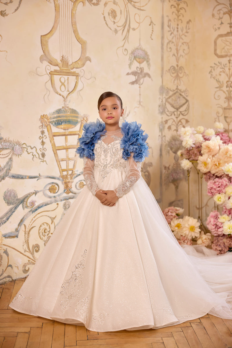 Girl wearing blue floral statement cape over communion gown