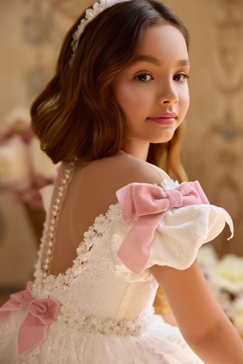 Back view of lace gown with cascading blush bows and long train