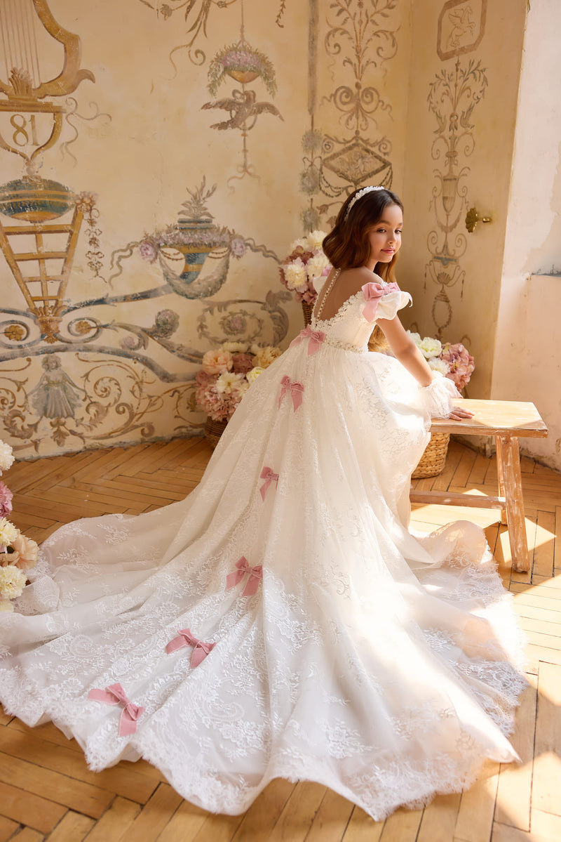 Back view of lace gown with cascading blush bows and long train