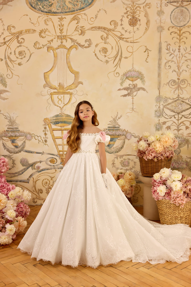 Girl in ivory lace communion gown with blush bows and train