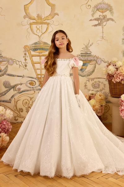 Girl in ivory lace communion gown with blush bows and train