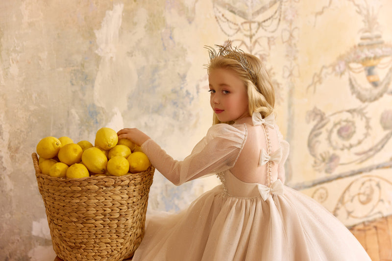 Back view of champagne flower girl gown with bows and train