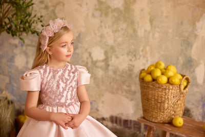 Close-up of blush pink flower girl dress with puff sleeves