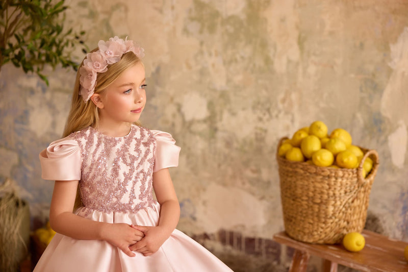 Close-up of blush pink flower girl dress with puff sleeves