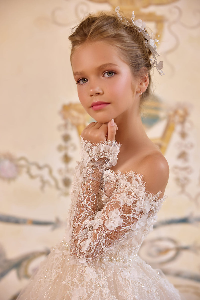 Close-up of lace sleeve and pearl detail on ivory flower girl gown