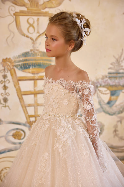 Side profile of girl in ivory lace party dress with floral hairpiece