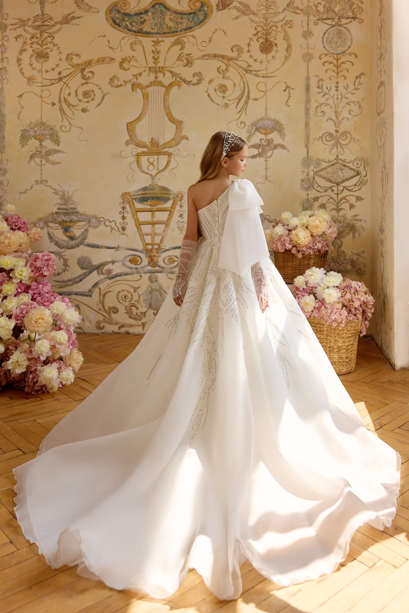 Off-white First Holy Communion dress with beaded accents and dramatic bow shoulder