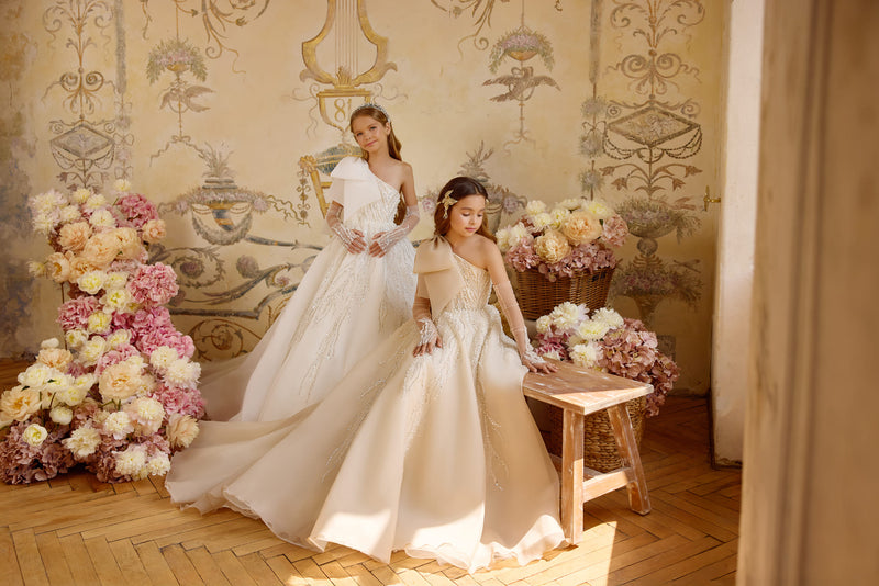 Champagne First Communion gown with statement bow and cascading embellishments