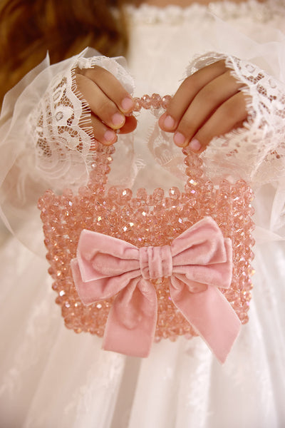 Close-up of pink crystal beaded flower girl bag with velvet bow