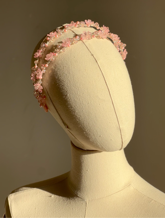 Pink floral double headband on mannequin – angled view