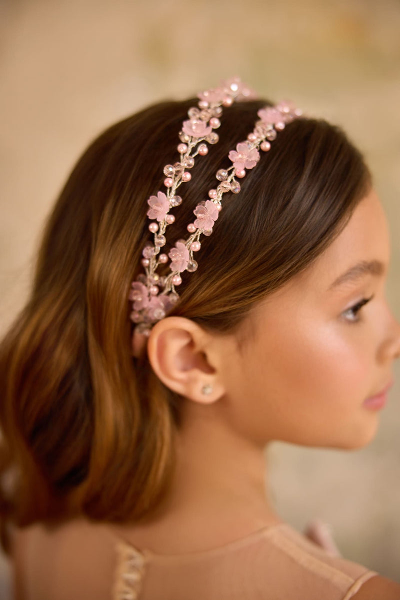 Girl wearing pink floral double headband with pearls and crystals