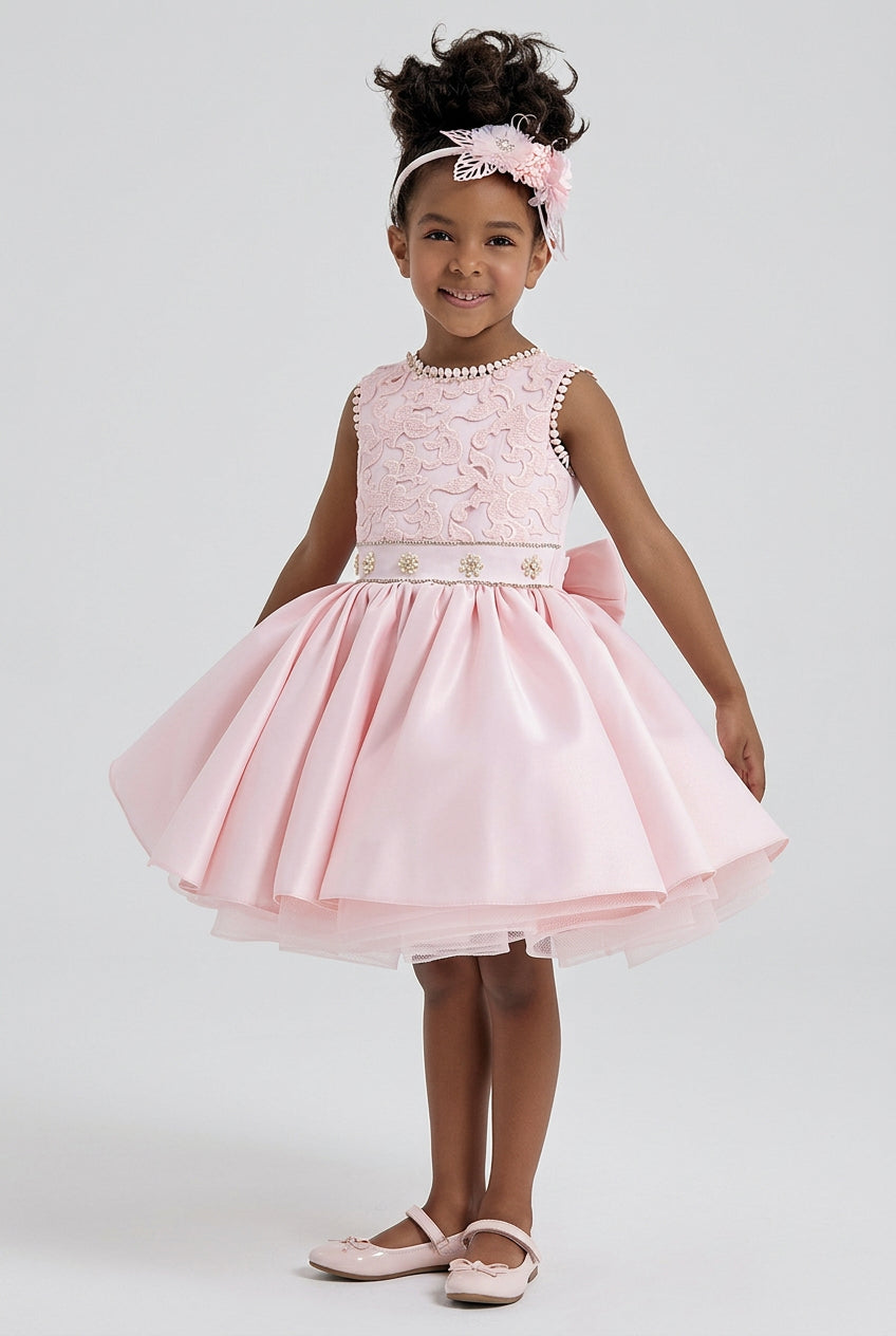 Pink flower girl dress with lace bodice and full satin skirt, knee length, front view on model by Mia Bambina Boutique