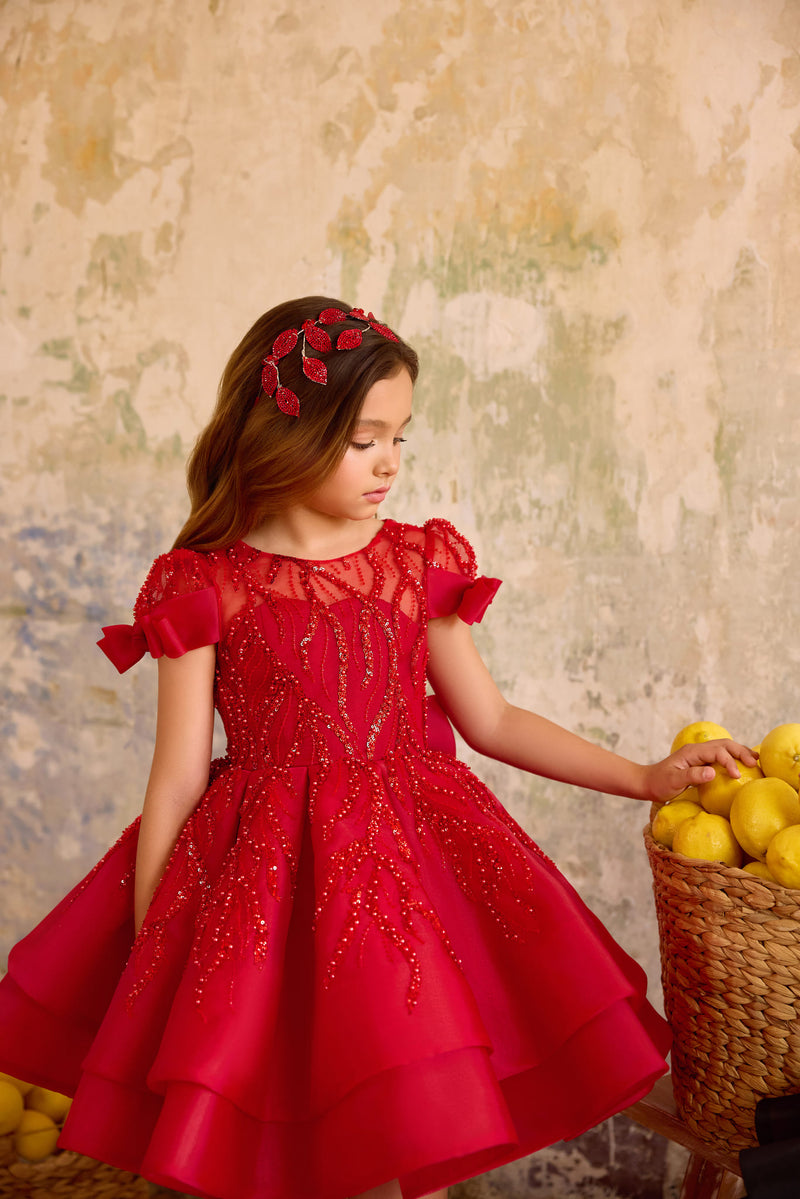 Girl wearing red sequin bow dress with puff sleeves and layered skirt