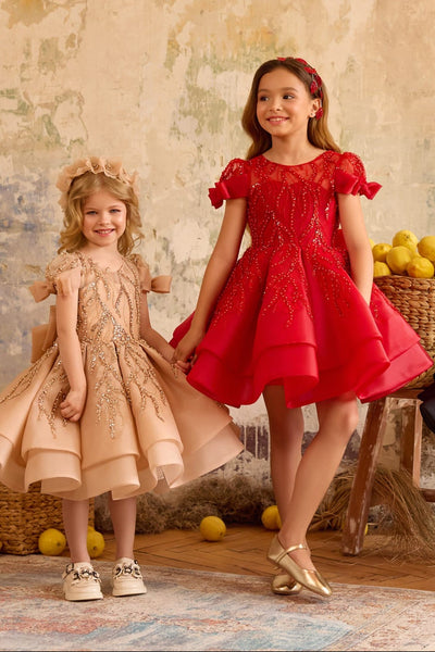 Girl wearing red sequin bow dress with puff sleeves and layered skirt