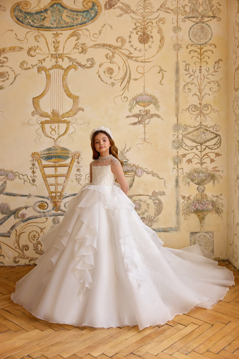 Girl wearing couture pearl-embellished First Communion dress in white