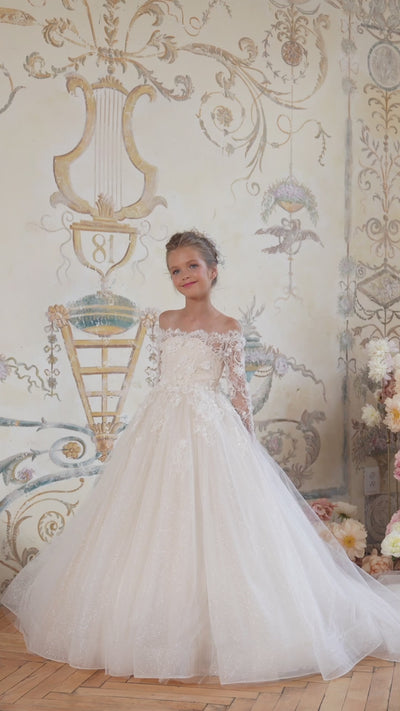 Girl in ivory lace flower girl dress with long sleeves and full skirt