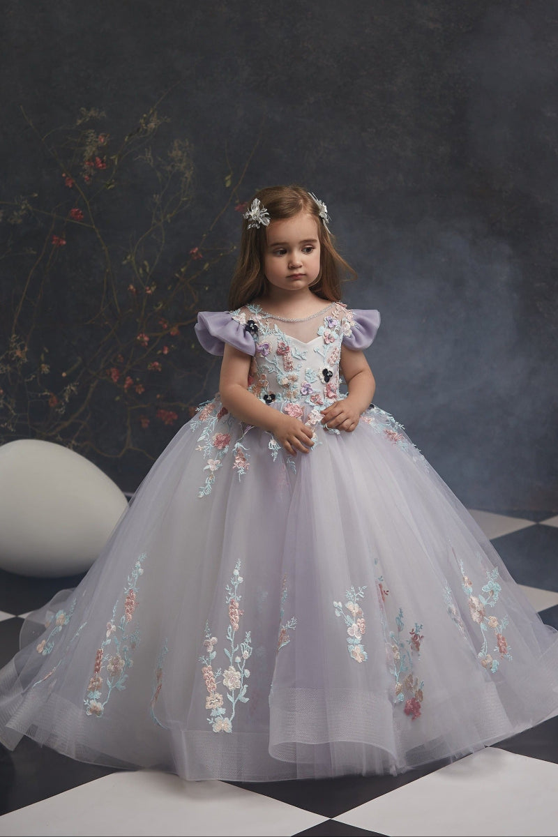 Young girl in Summer Flower Girl Dress for Wedding standing on a checkered floor with a dark wall background