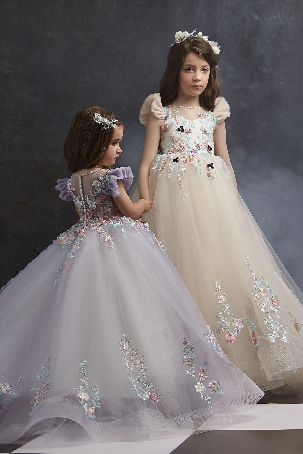 Two young girls in Summer Flower Girl Dress for Wedding standing on a checkered floor with a dark background.