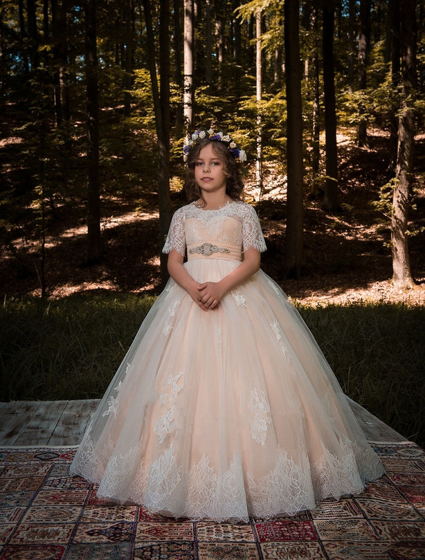 Young girl in a Verona Blush Flower Girl Tulle Dress standing in a forest