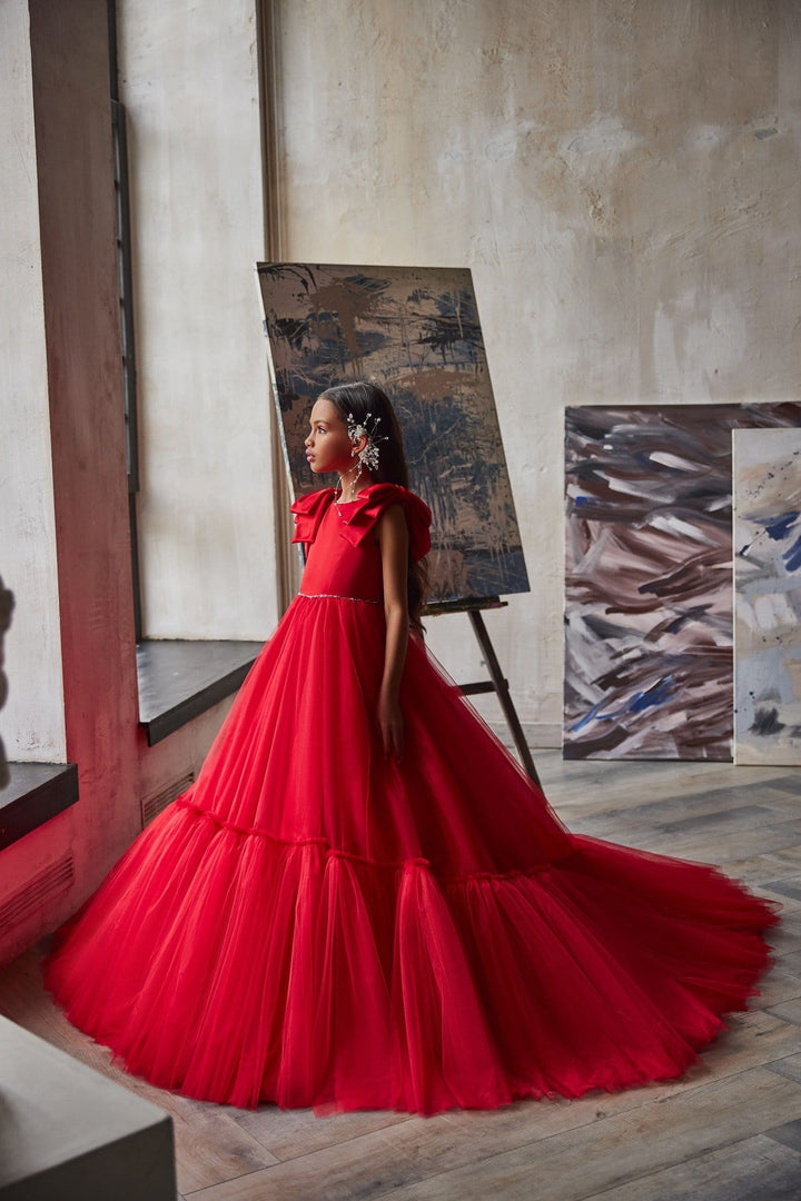 Red ball gown for girls with satin shoulder bows and floor-length tulle skirt with train, side view - Mia Bambina Boutique